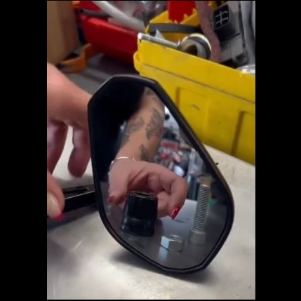 reflet d'une main dans un rétroviseur